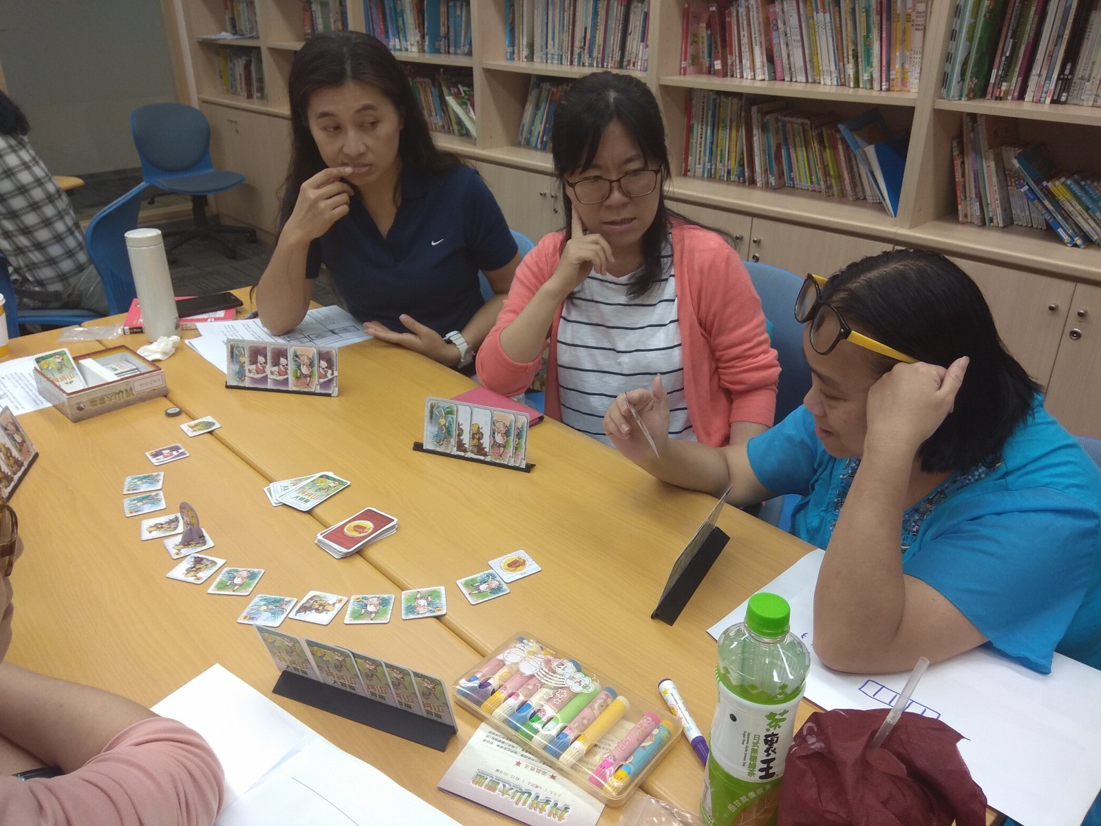 Teachers played board games together, discussing how to make good use of it.